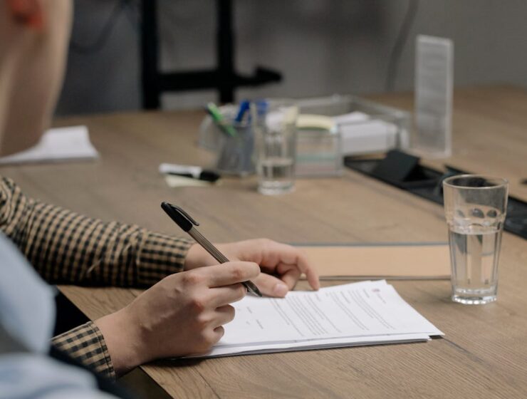 Person reviewing paperwork and documents at a desk — independent contractor admin