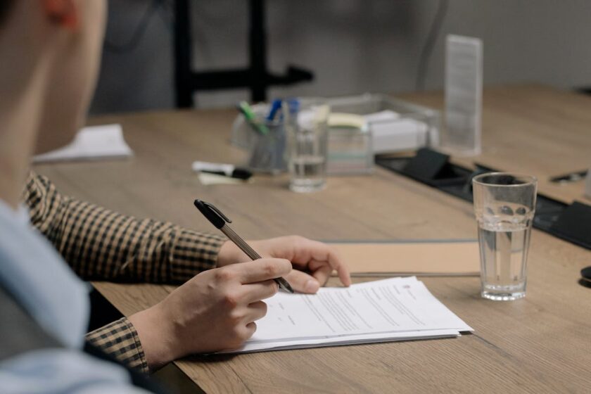 Person reviewing paperwork and documents at a desk — independent contractor admin